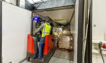 Warehouse worker loading a refrigerated LTL carrier trailer